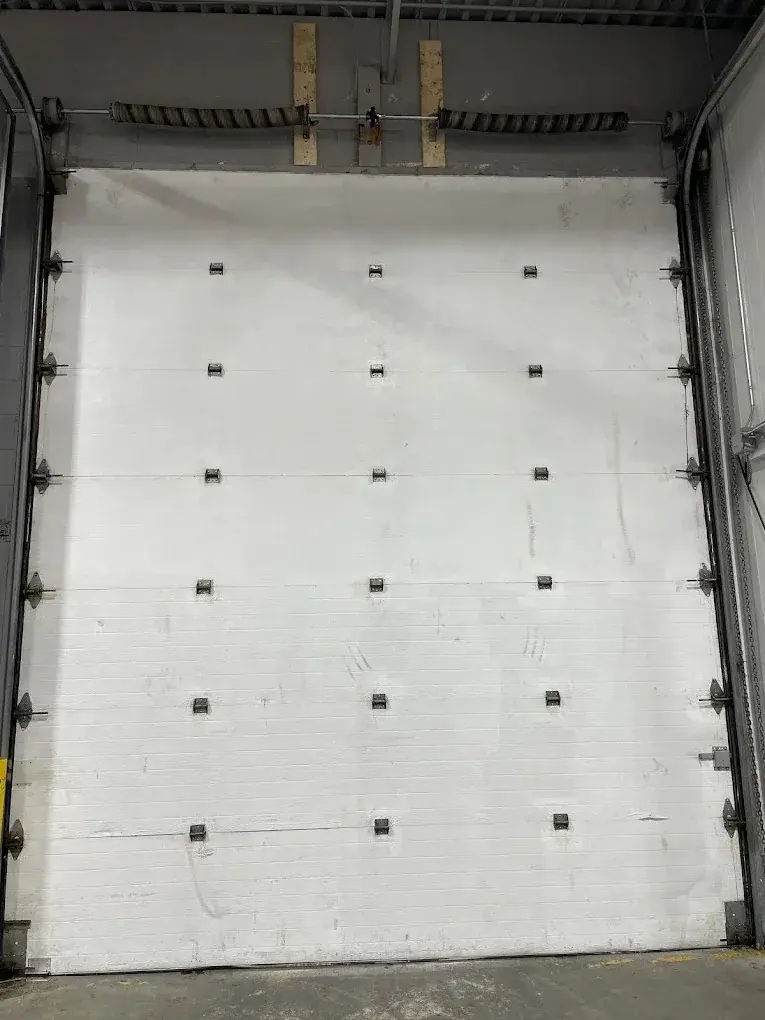 Interior view of a large white commercial sectional garage door