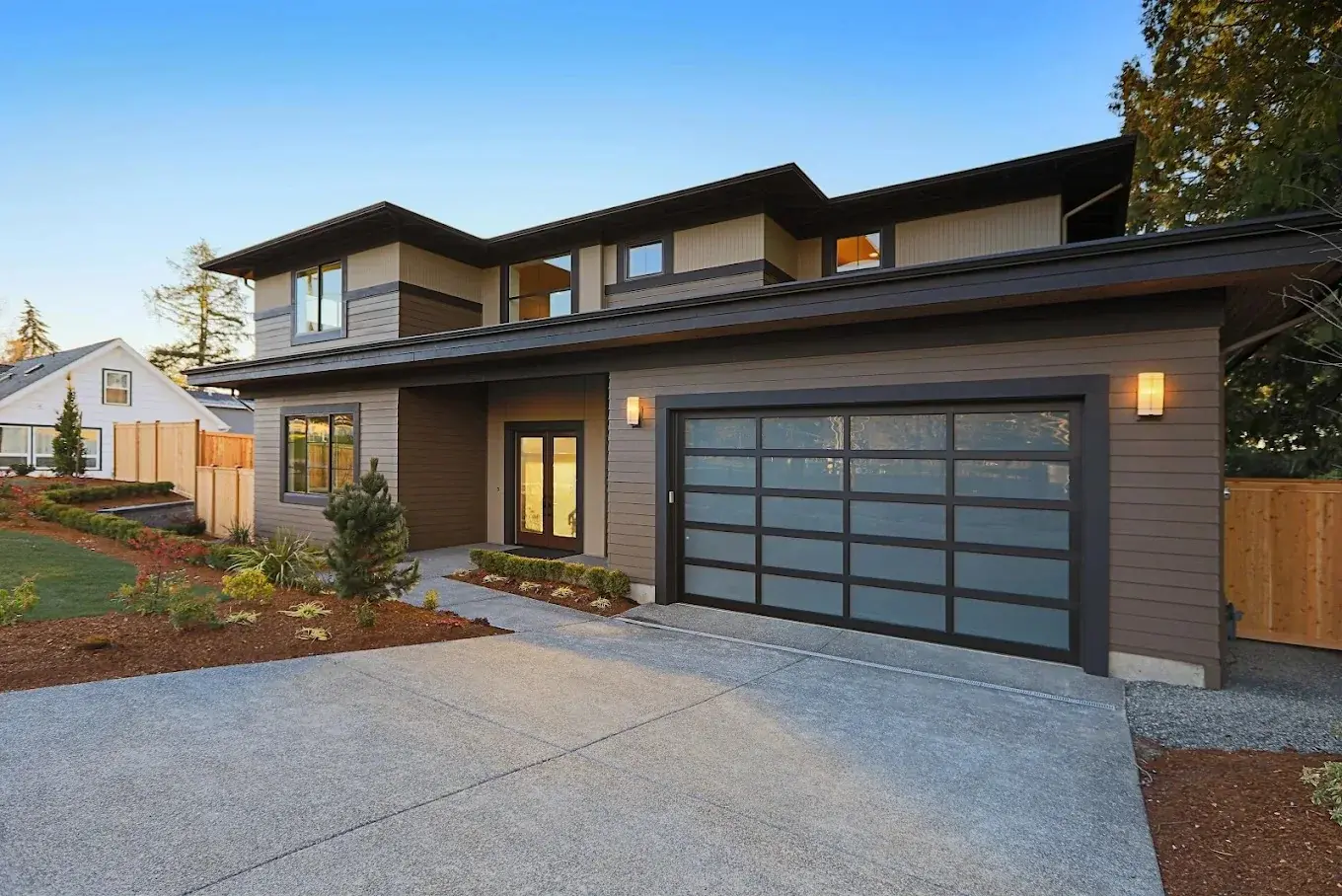 Modern luxury home with black glass garage doors