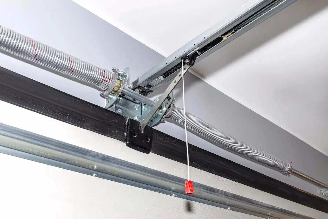 Close-up of garage door torsion spring and overhead track hardware