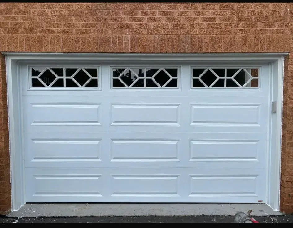 White raised-panel garage door with decorative diamond glass windows