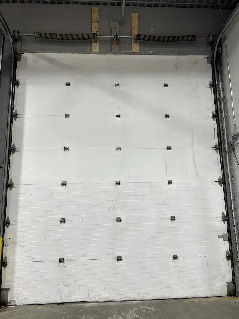 Interior view of a large white commercial sectional garage door