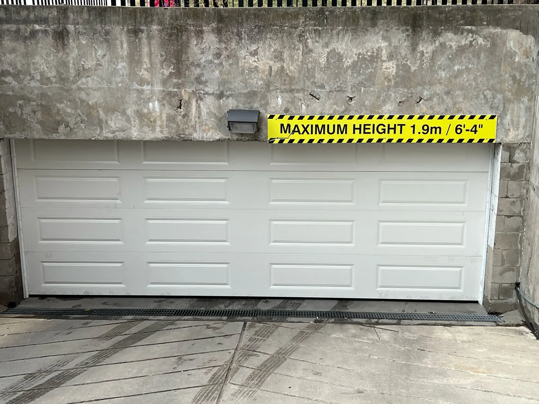 White garage door installed below a maximum height clearance sign
