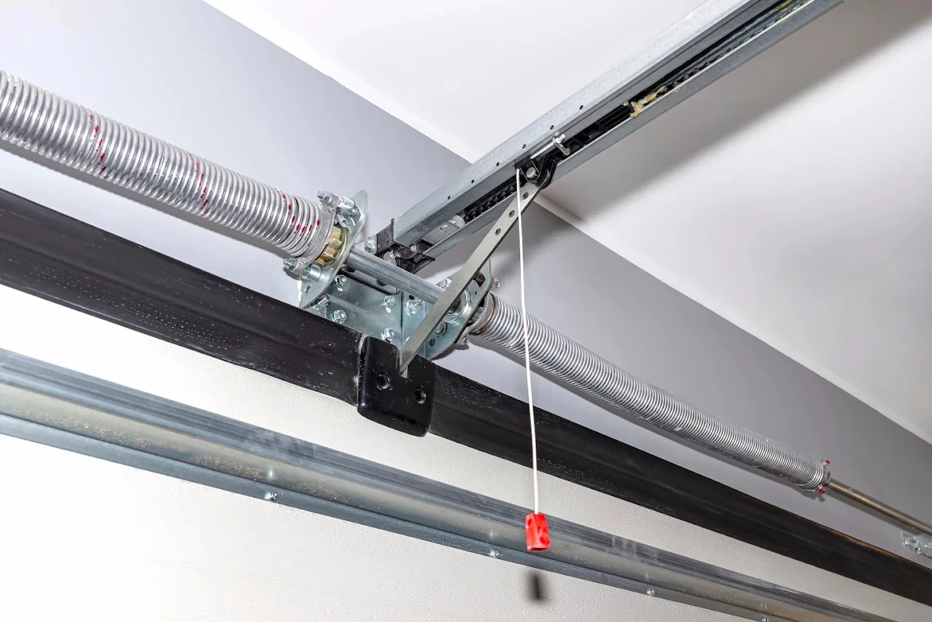 Close-up of garage door torsion spring and overhead track hardware