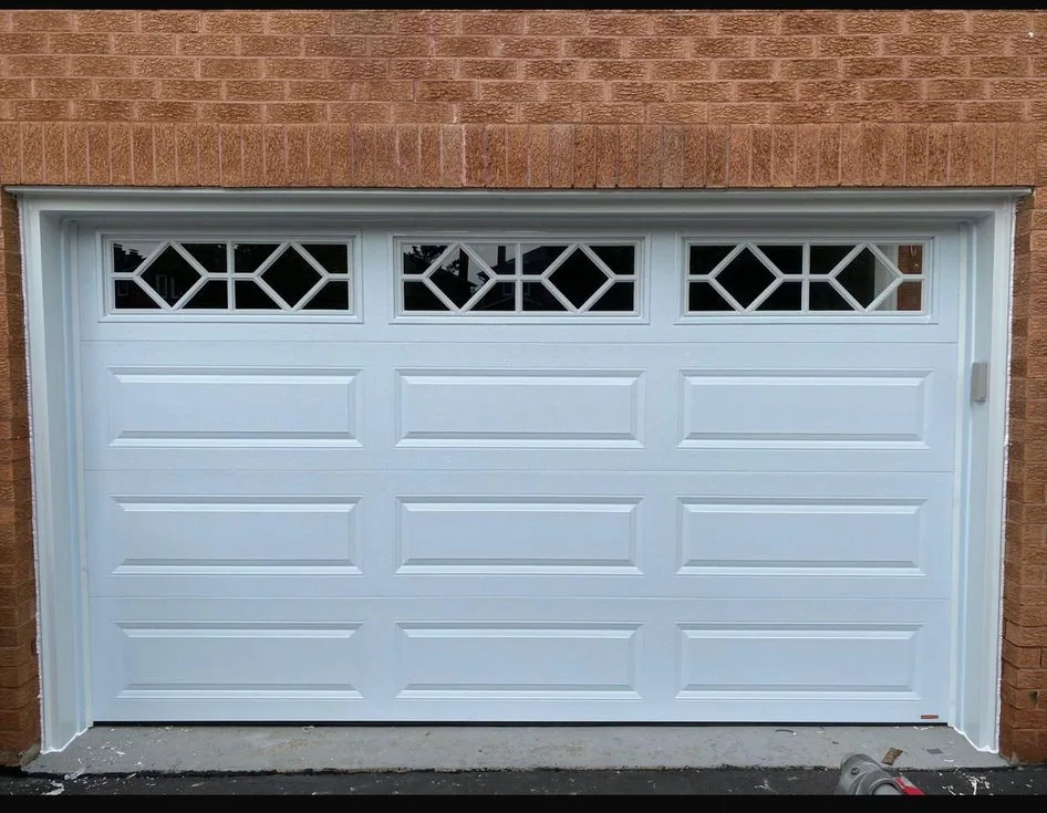 White raised-panel garage door with decorative diamond glass windows